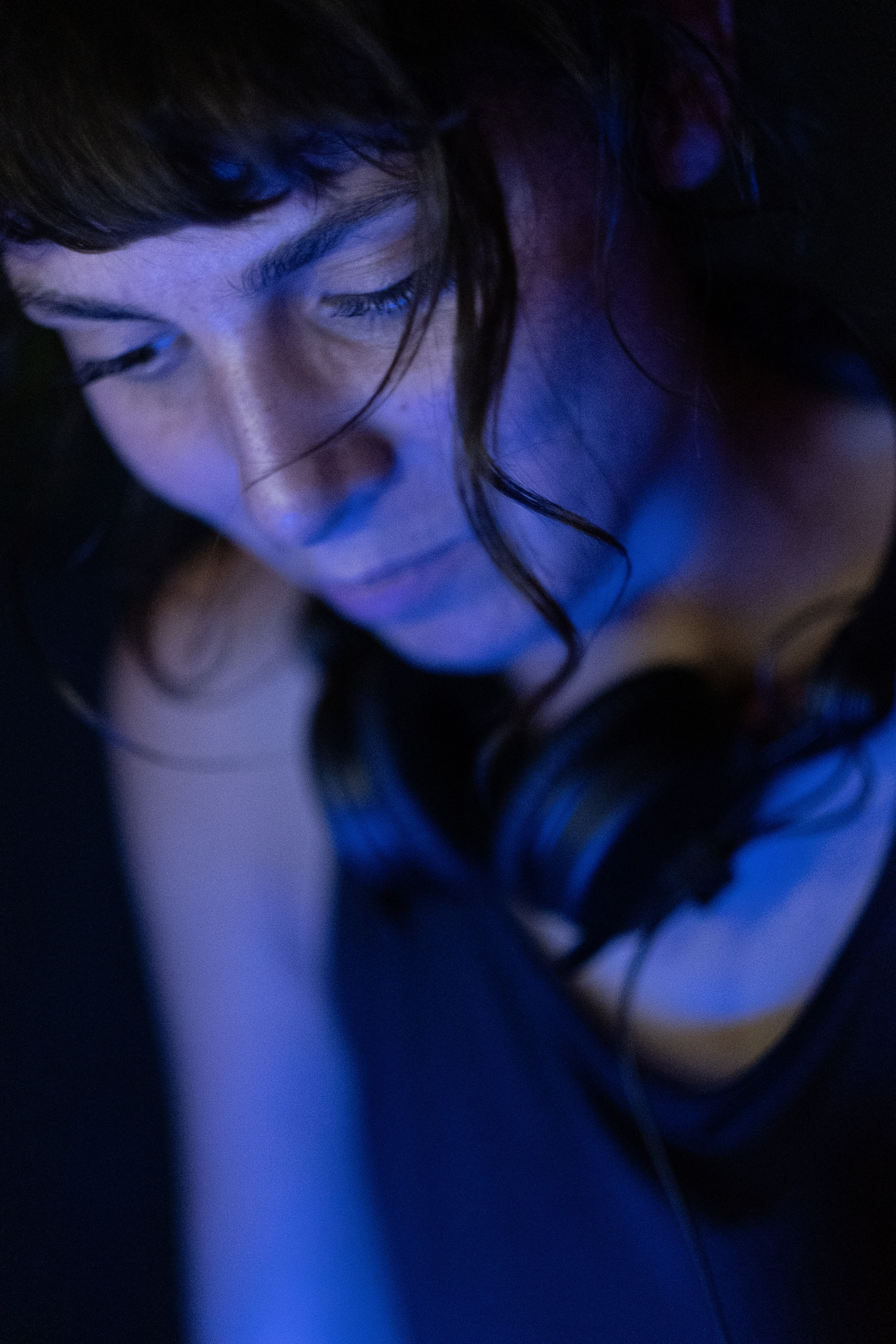 A photo of Safira with a lot of focus and some headphones around her neck.